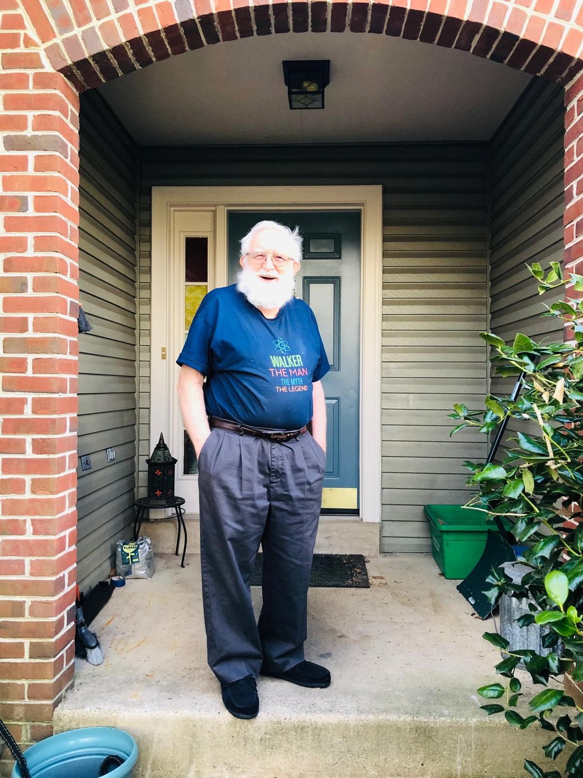 Grandfather smiling in a blue T-shirt beneath a brick doorway arch