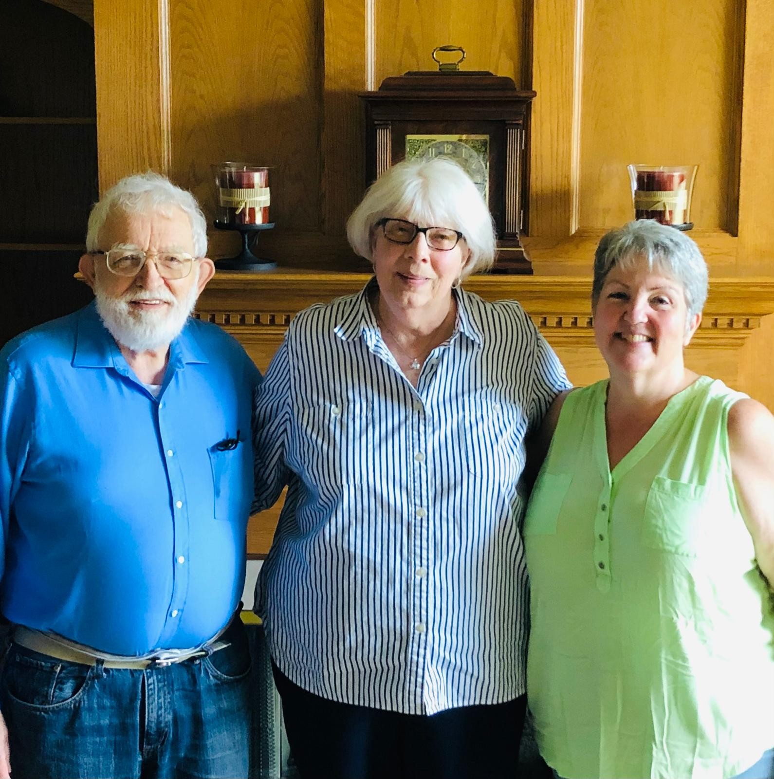 Three people standing together indoors